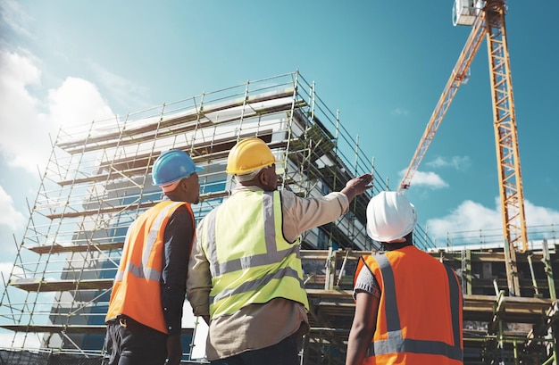 Engineering construction site and team outdoor for building project planning and architecture Black woman and men contractor together for development and safety assessment discussion in city