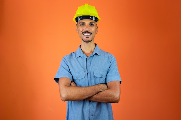 Engineers day Black Man in Safety Helmet and Blue Shirt isolated on orange