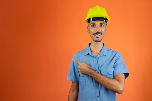 Engineers day Black Man in Safety Helmet and Blue Shirt isolated on orange