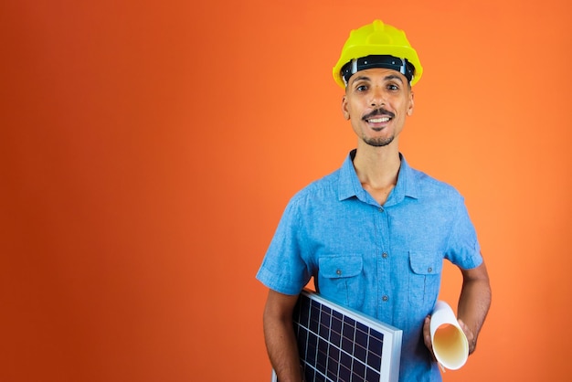 Engineers day Black Man in Safety Helmet and Blue Shirt isolated on orange