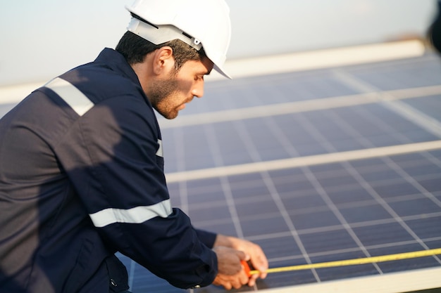 Engineers installing solar panels on roof Male engineers walking along rows of photovoltaic panels