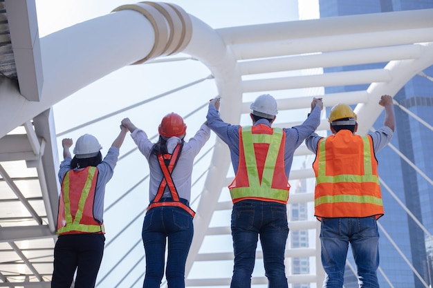 Engineers rise hands up with success concept