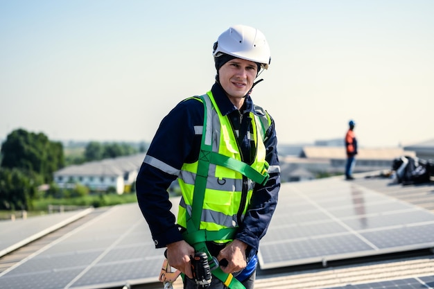 Photo engineers with safety helmet checking solar system at solar power farm