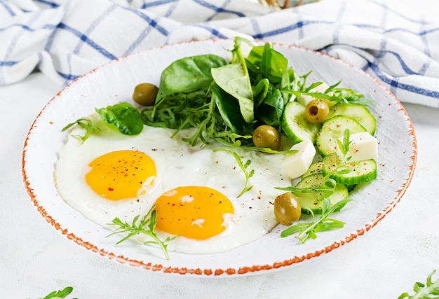 English breakfast fried eggs cheese cucumber olives and spinach American food