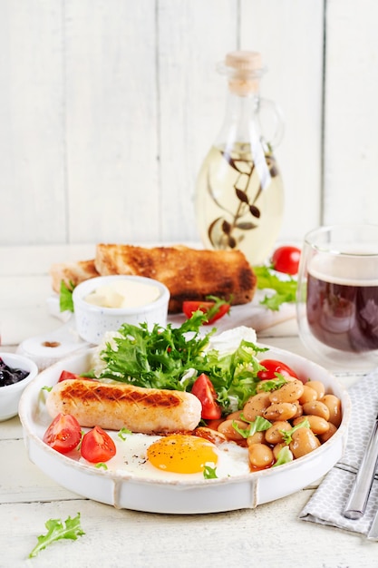 English breakfast Keto breakfast Fried egg beans chicken sausage and coffee cup