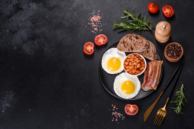 English breakfast with fried eggs bacon beans tomatoes spices and herbs