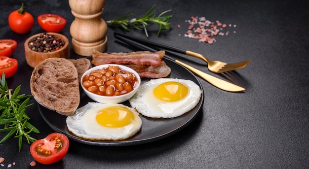 English breakfast with fried eggs bacon beans tomatoes spices and herbs