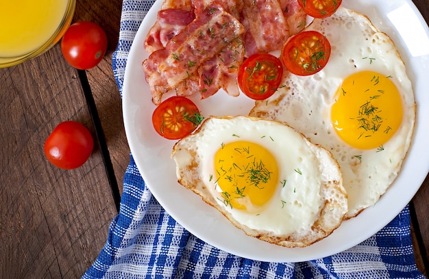 English breakfast with toast, egg, bacon and vegetables in a rustic style on wooden