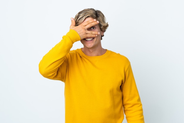 English man over white covering eyes by hands and smiling