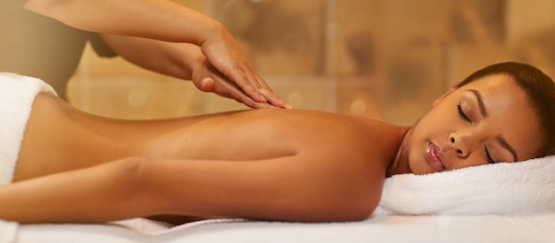 Enjoy a day of pampering Cropped shot of a young woman getting a massage at the spa