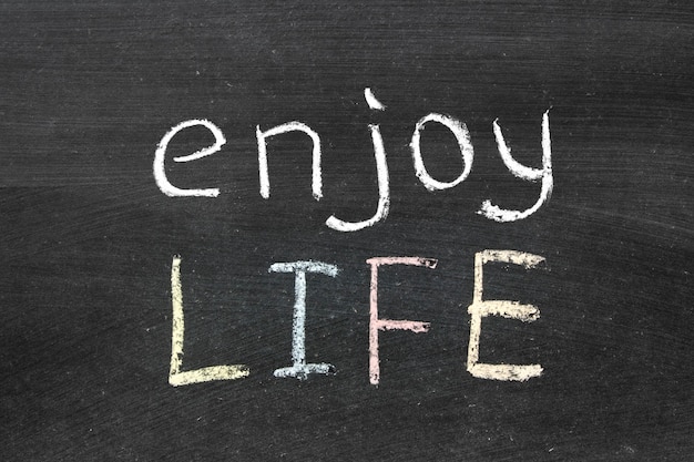 Enjoy life phrase handwritten on the school blackboard