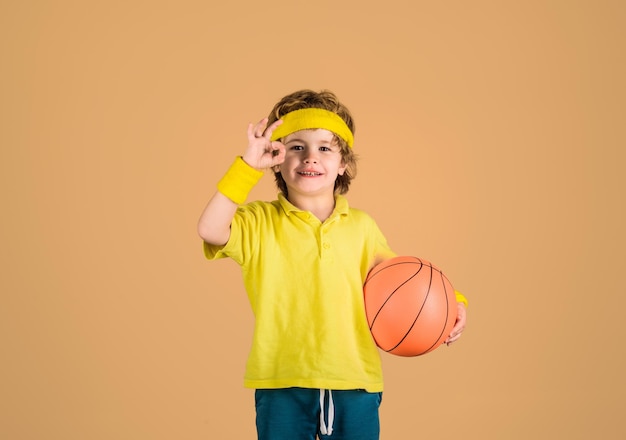 Enjoy sport game cute boy playing basketball child boy in sportswear holds ball basketball training