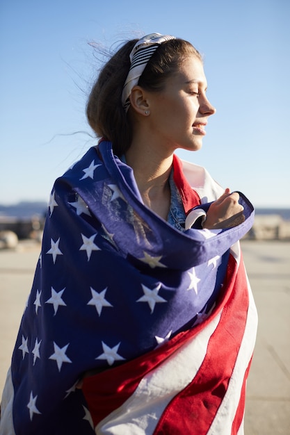 Enjoyable girl covered with American flag