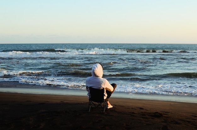 Enjoying life Back side of young man looking at the sea vacations lifestyle concept