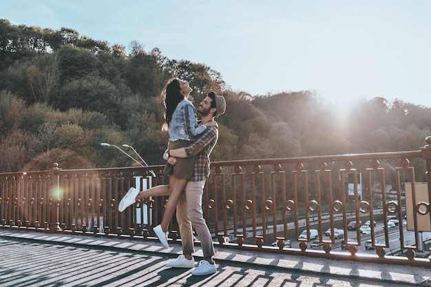 Enjoying sunset together. Full length of handsome man carrying young attractive woman 