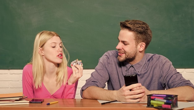 Enjoying time in college Studying in college or university Friends students studying university College fun Modern education Having fun in college Guy and girl carefree sit at desk in classroom