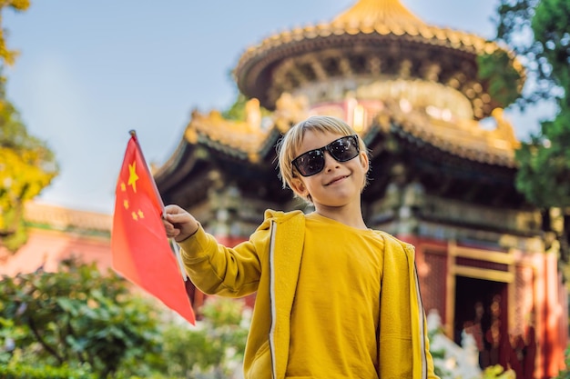 Enjoying vacation in China Young boy with national chinese flag in Forbidden City Travel to China with kids concept Visa free transit 72 hours 144 hours in China