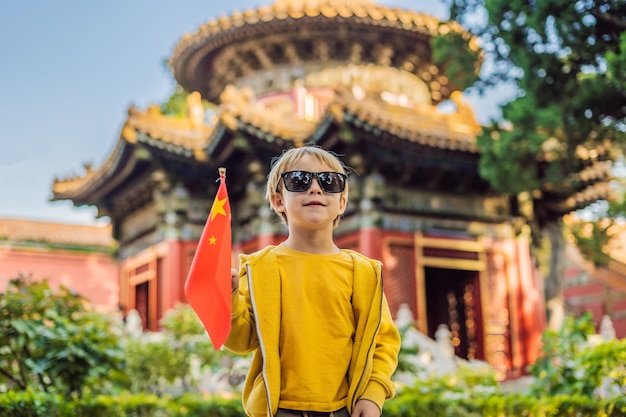 Enjoying vacation in China Young boy with national chinese flag in Forbidden City Travel to China with kids concept Visa free transit 72 hours 144 hours in China