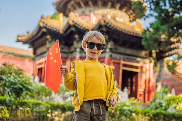 Enjoying vacation in China Young boy with national chinese flag in Forbidden City Travel to China with kids concept Visa free transit 72 hours 144 hours in China