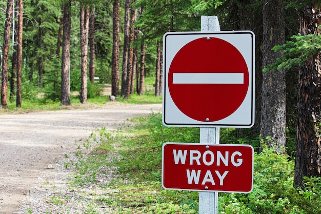 Photo a do not enter wrong way sign beside a gravel road