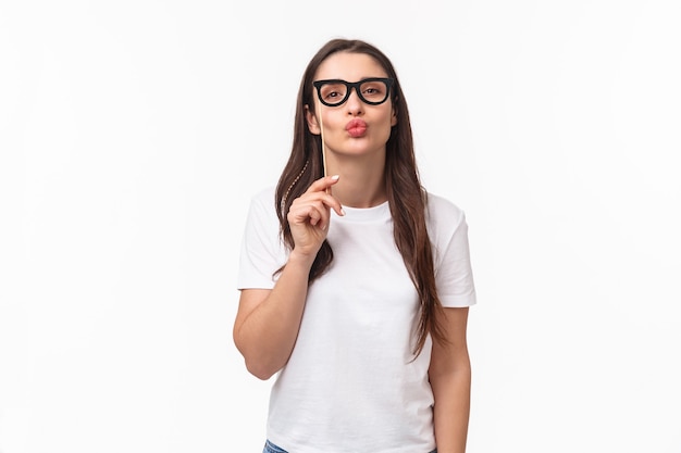 Entertainment, fun and holidays concept. Portrait of silly and cute young attractive girl wearing carnaval mask glasses