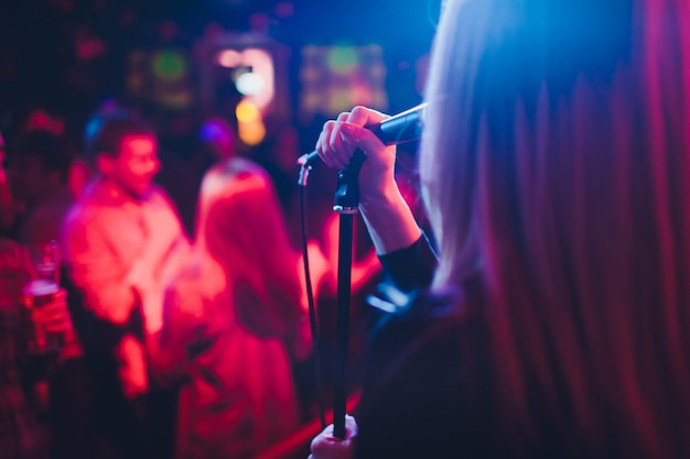 Entertianment at a wedding. A female singer is interacting with the crowd while a man plays an acoustic guitar.