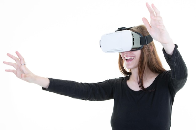 Enthusiastic girl in VR glasses looking with virtual reality headset standing over white background