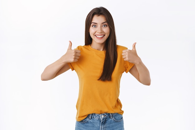 Enthusiastic, thrilled young woman think your idea awesome, rate good movie, showing thumbs-up smiling happy and giving her approval, agree or accept something amazing, white background