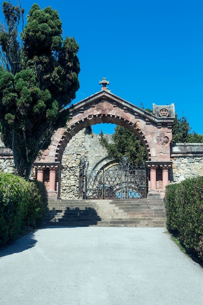 Entrance in the form of a stone arch and iron gate with railings with stairs