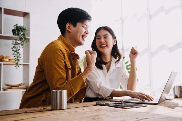 Entrepreneur Asian businessman and businesswoman discussing new business project in tablet in modern Meeting In Modern Office Asian business casual concept