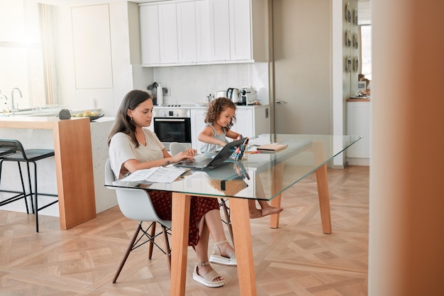 Entrepreneur or small business owner working on laptop while daughter doing drawing at home Startup worker typing reading and send email on computer while working online and girl playing alone