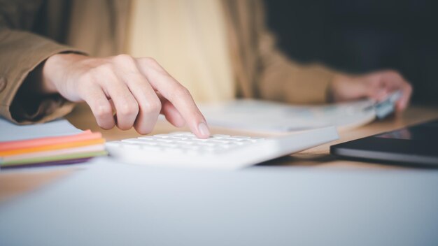 Photo entrepreneur using a calculator to calculate numbers profit and loss statement review