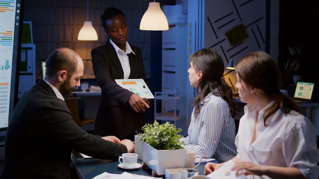 Entrepreneur woman with dark skin overworking in company office meeting room