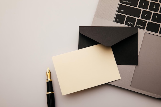 Envelope and laptop on white table background Home office