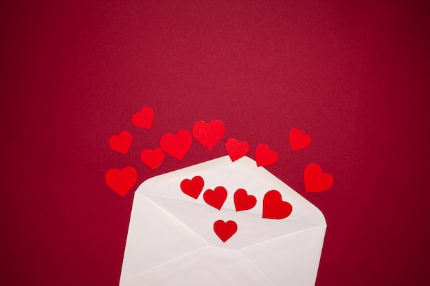 Envelope with hearts on red background. Romance and love concept