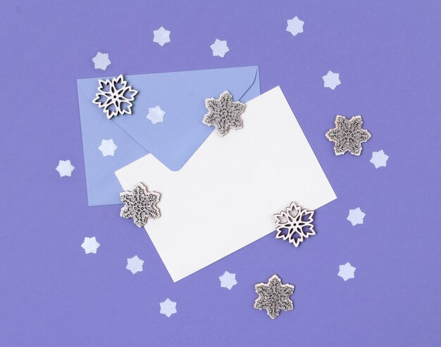 Envelope with letter and snowflakes on purple table