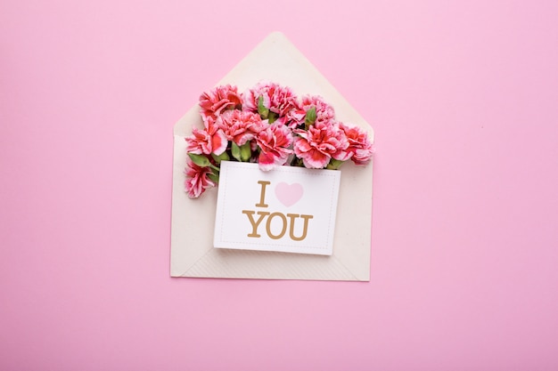 An envelope with pink flowers and a card I love you on pink