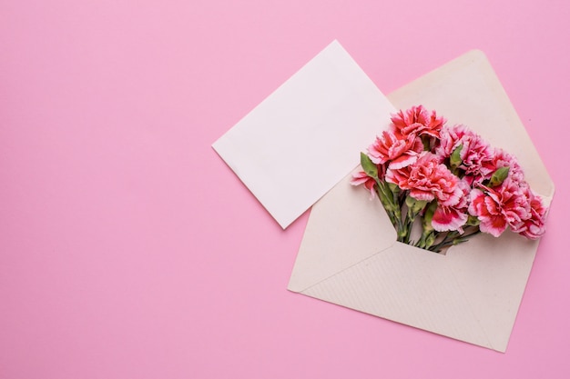 An envelope with pink flowers and a present card on pink