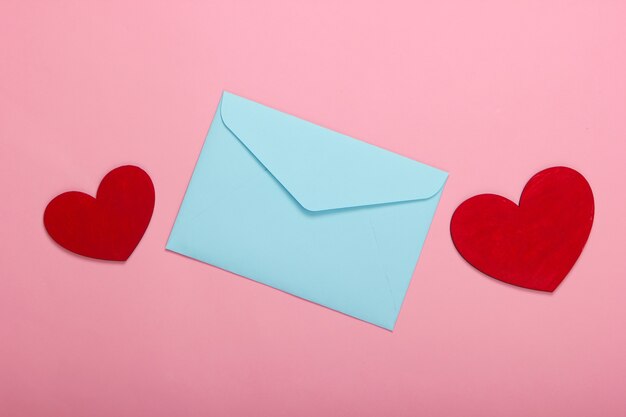 Envelope with red hearts valentines on pink pastel