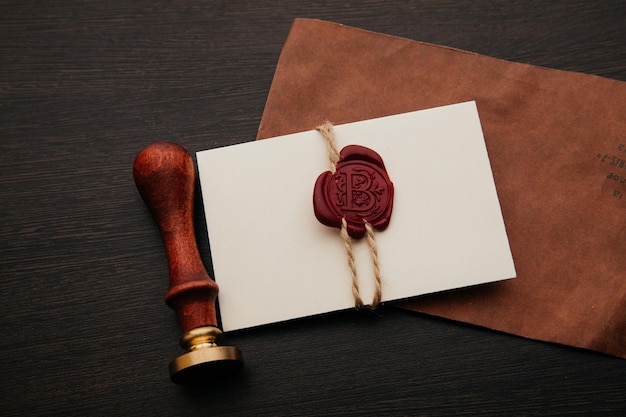 Envelope with wax seal stamp and pen on a dark table Notary tools