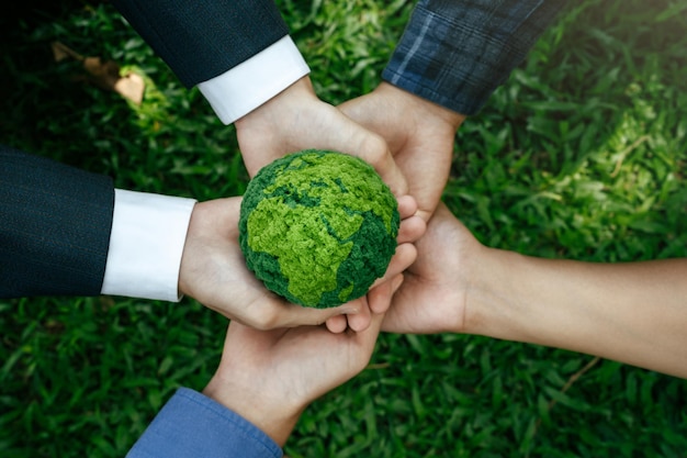 Photo environment world earth day concept hands of people holding green globe for care saving protecting planet together sustainable environment development green business energy renewable