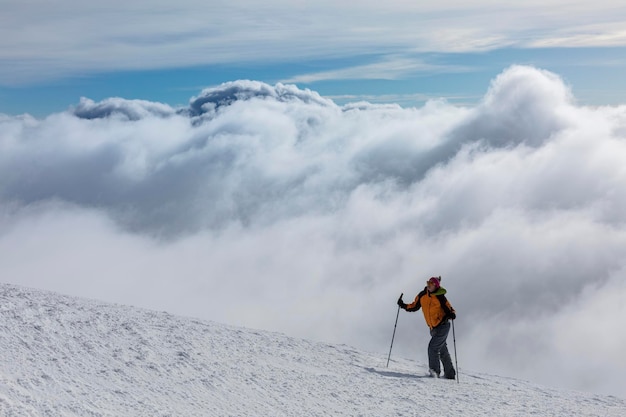 Epic scene of woman at the summit of mountain as symbol of life success Silhouette of man tourist standing at top Incredible panoramic view of snow capped mountain ridge