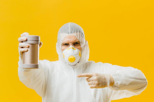 epidemiologist on protective clothes holding and pointing to container