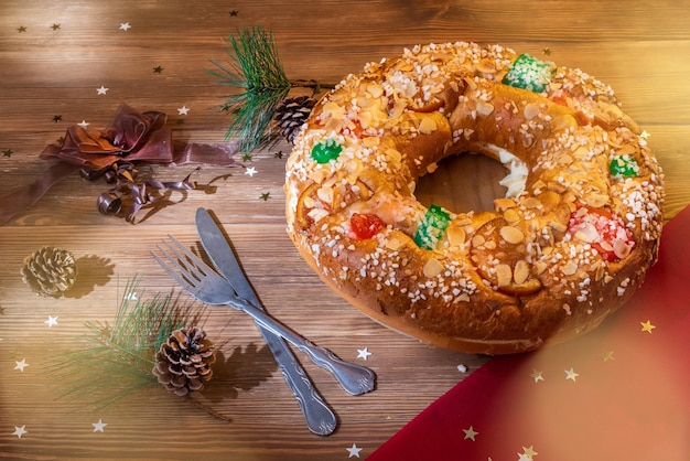 Epiphany cake with candied fruits Roscon de Reyes on a wooden table Typical Spanish dessert