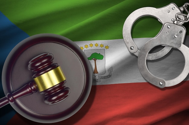 Equatorial Guinea flag with judge mallet and handcuffs in dark room Concept of criminal and punishment background for judgement topics