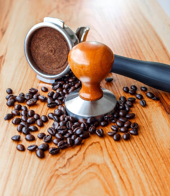 Equipment of barista coffee tool portafilter with tamper and roasted coffee beans in a coffee shop