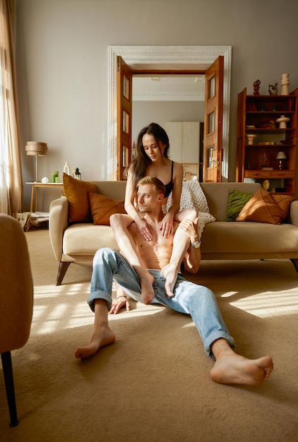 Erotic half dressed couple rest together in home living room