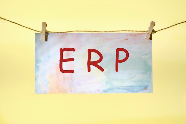 ERP text on colored paper hanging on a rope with clothespins concept for enterprise resource planning with icon of inventory financials hrm production service purchasing and mrp