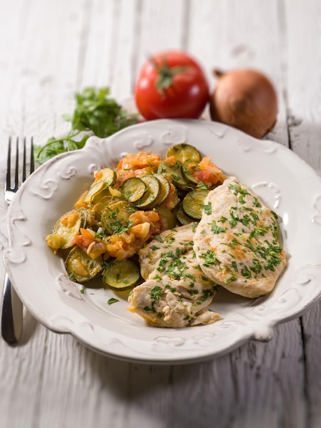 Escalope with tomatoes and zucchinis selective focus