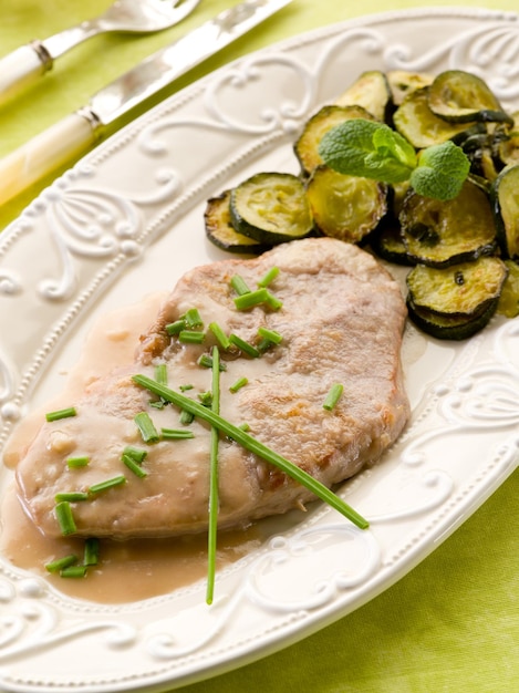 Escalope with white wine sauce and sauteed zucchinis